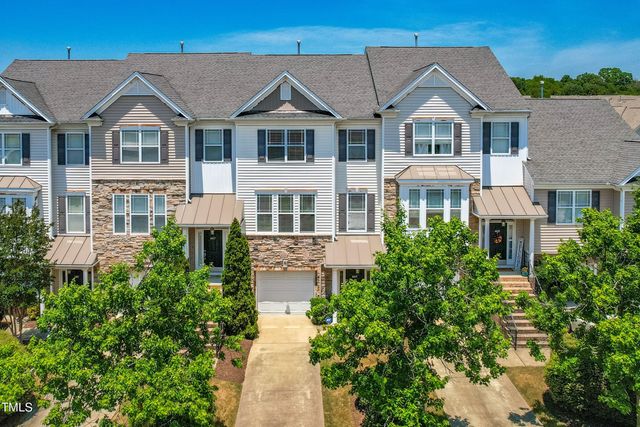 a front view of a residential houses with yard and green space