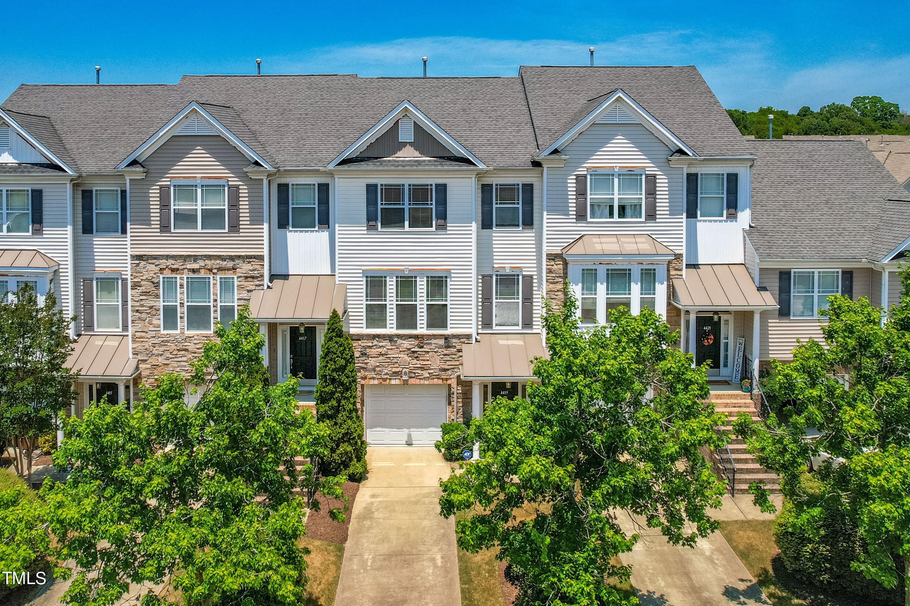 a front view of a residential houses with yard and green space