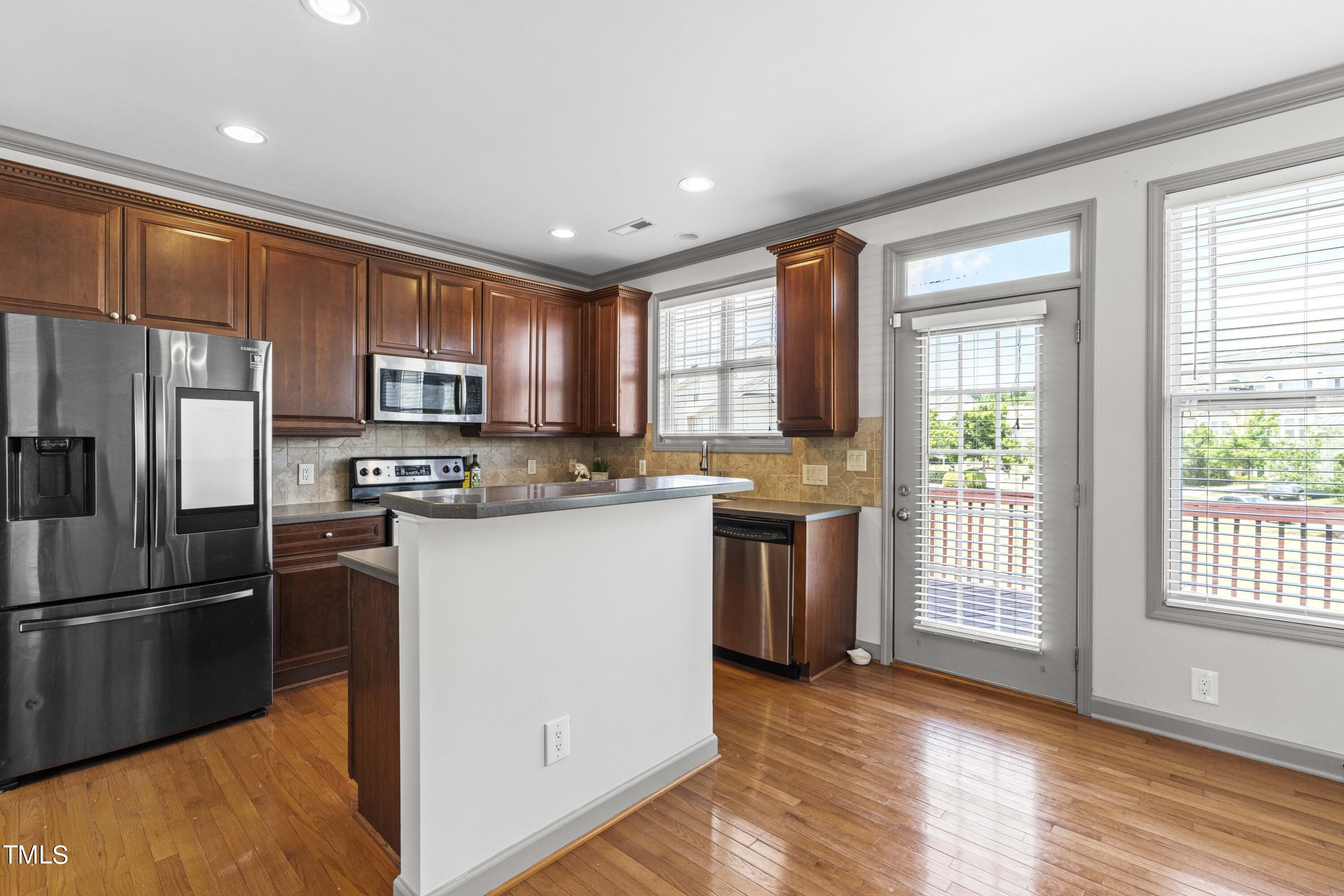 4419 Iyar Way Wake Forest, NC 27587 - Photo 8 of 26 a kitchen with stainless steel appliances granite countertop a refrigerator a stove top oven a sink and dishwasher with wooden floor