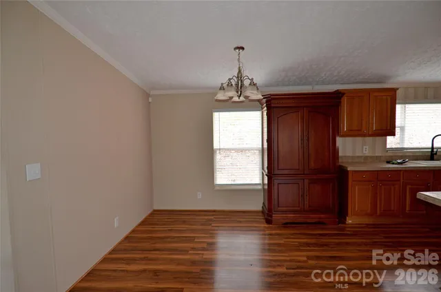 a view of a kitchen with wooden floor and cabinets