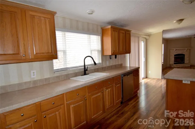 a kitchen with stainless steel appliances a sink cabinets and wooden floor