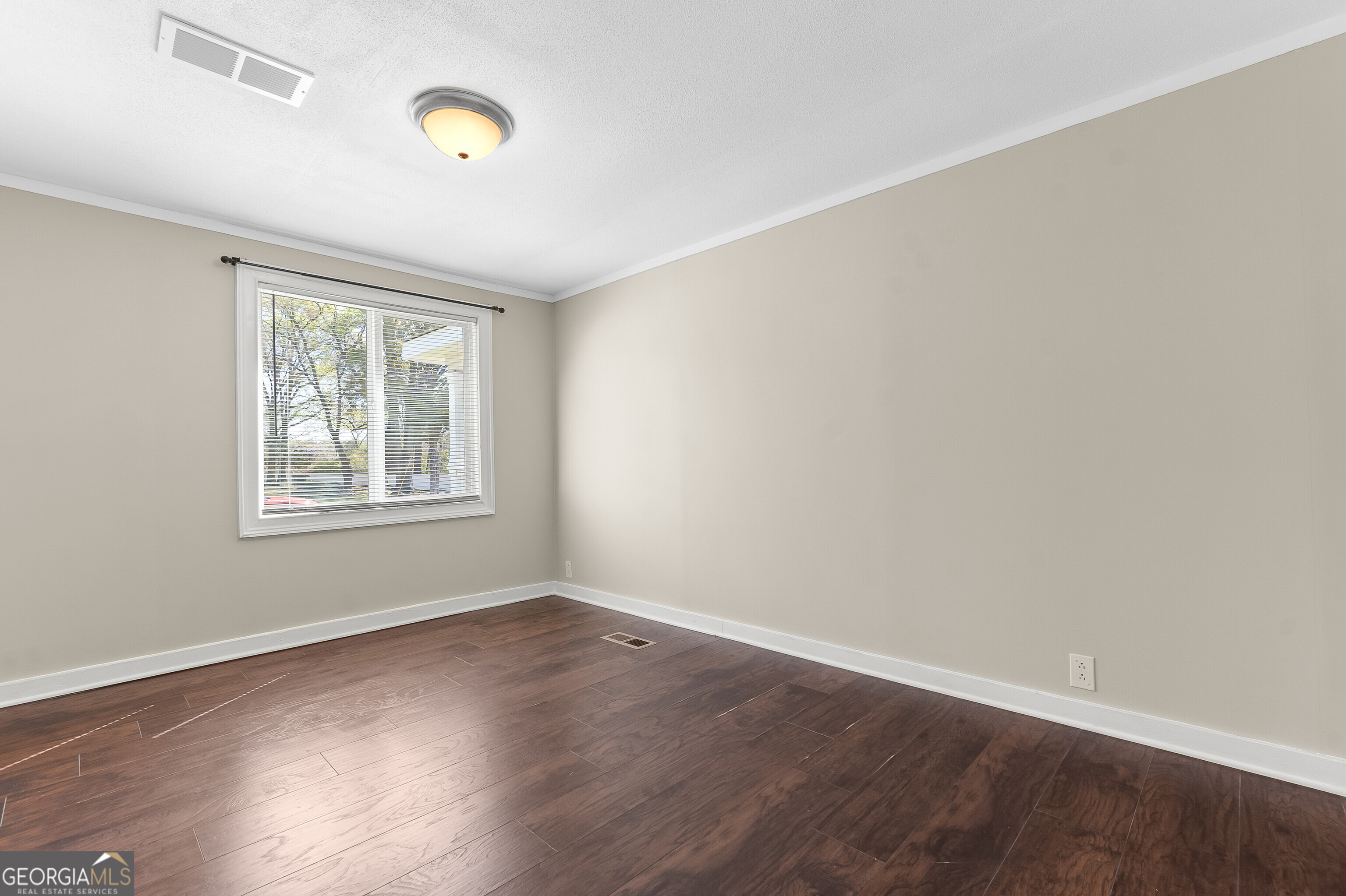129 Walnut Street Bonaire, GA 31005 - Photo 21 of 31 a view of an empty room with wooden floor and a window