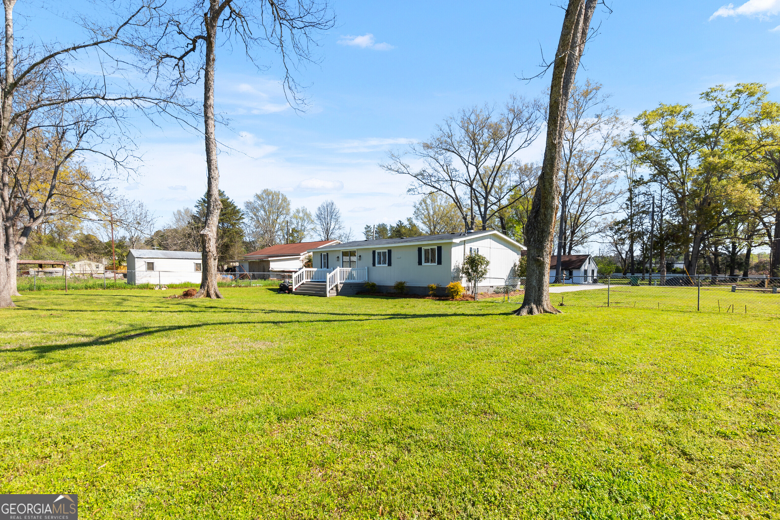 129 Walnut Street Bonaire, GA 31005 - Photo 28 of 31 a yellow house with trees in front of it