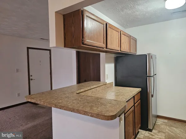 a kitchen with stainless steel appliances granite countertop a refrigerator a stove and white cabinets