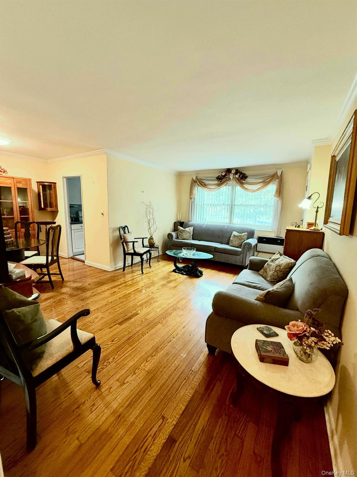 5805 251st Street, Unit 147 Queens, NY 11362 - Photo 2 of 7 a living room with furniture and wooden floor