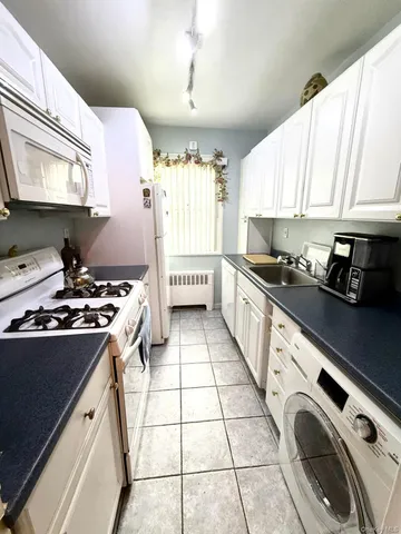 a kitchen with a sink stove top oven and cabinets
