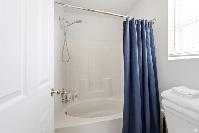 5485 Heather Way Tooele, UT 84074 - Photo 30 of 41 Bathtub and shower combination featuring white subway tile surround, integrated shelving, and a chrome shower head with a handheld sprayer