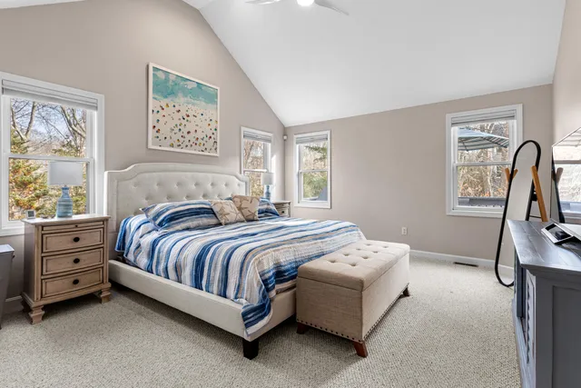 a bedroom with a bed and a dresser next to a window