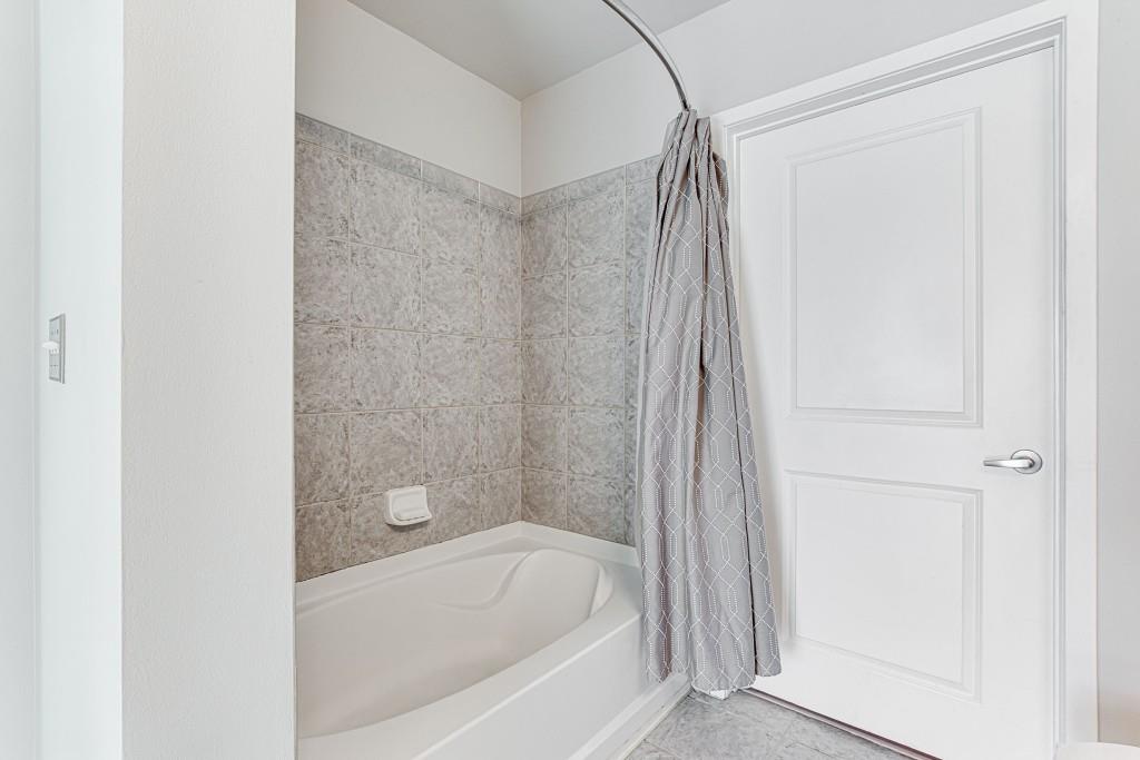 250 Pharr Road Northeast, Unit 216 Atlanta, GA 30305 - Photo 14 of 38 a bathroom with a bathtub and a shower