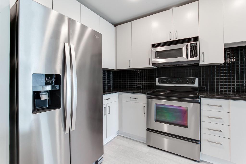 250 Pharr Road Northeast, Unit 216 Atlanta, GA 30305 - Photo 5 of 38 a kitchen with stainless steel appliances a stove a microwave and a refrigerator