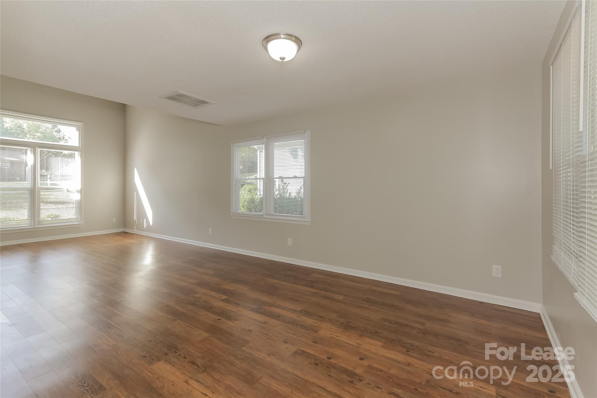 926 Eldorado Avenue Charlotte, NC 28262 - Photo 11 of 17 an empty room with wooden floor and windows