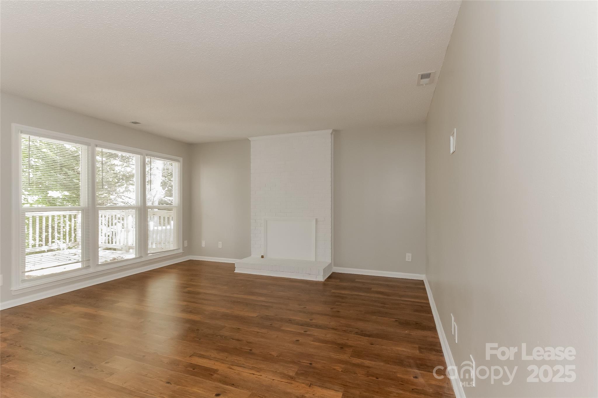 926 Eldorado Avenue Charlotte, NC 28262 - Photo 6 of 17 an empty room with wooden floor and windows
