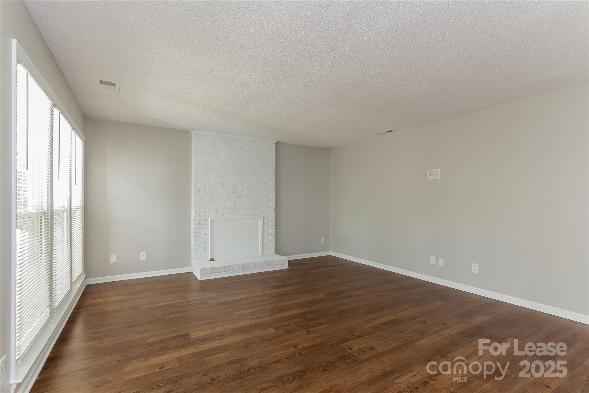 926 Eldorado Avenue Charlotte, NC 28262 - Photo 7 of 17 a view of an empty room with wooden floor and a window