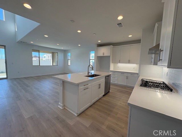 3706 Leafgreen Road Corona, CA 92883 - Photo 3 of 5 a large white kitchen with sink a window and stainless steel appliances