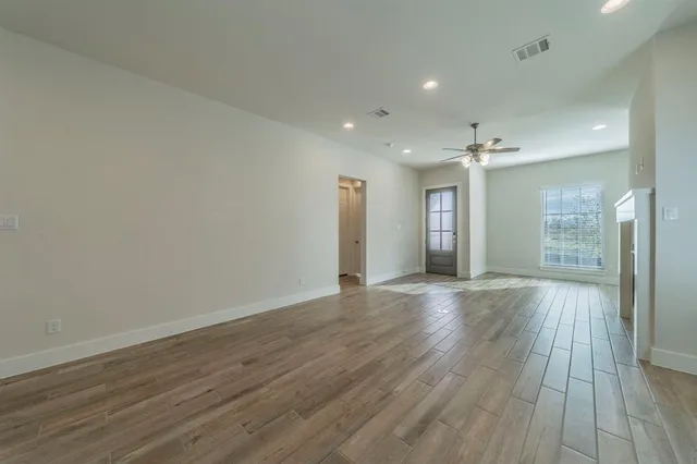 a large space with chandelier fan and windows