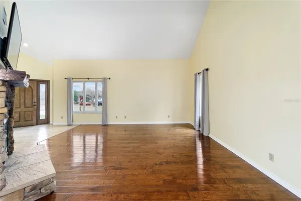 a view of empty room with wooden floor