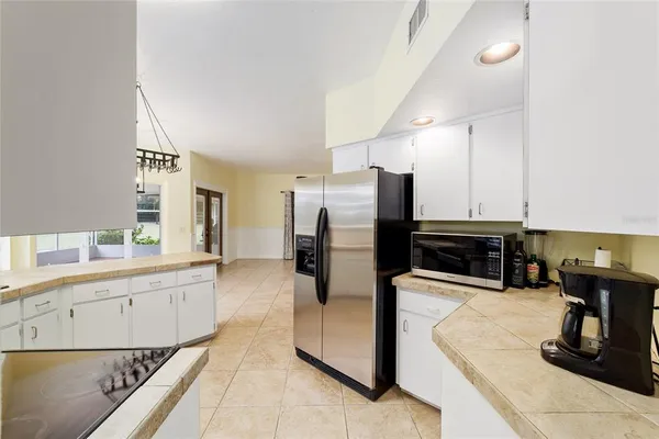 a kitchen with stainless steel appliances kitchen island granite countertop a stove a kitchen island a refrigerator and a view of living room