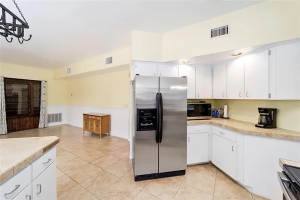 a kitchen that has a lot of cabinets and a wooden floor