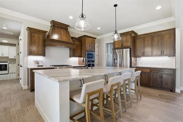 a kitchen with kitchen island granite countertop a sink a counter space appliances and cabinets