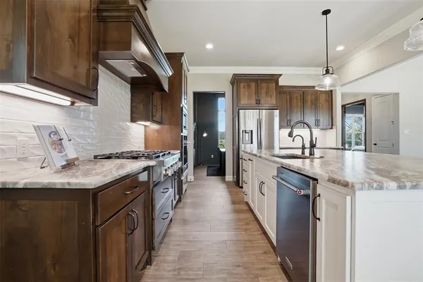 a kitchen with granite countertop a sink and a refrigerator