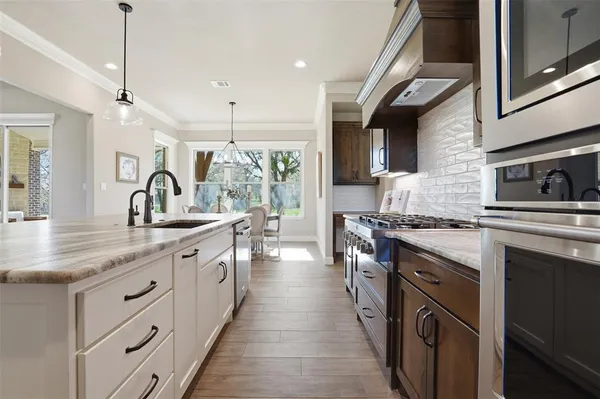 a kitchen with stainless steel appliances granite countertop a sink stove and cabinets