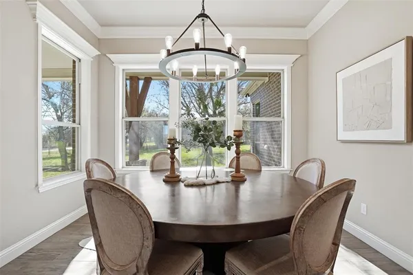 a dining room with furniture a large window and a chandelier