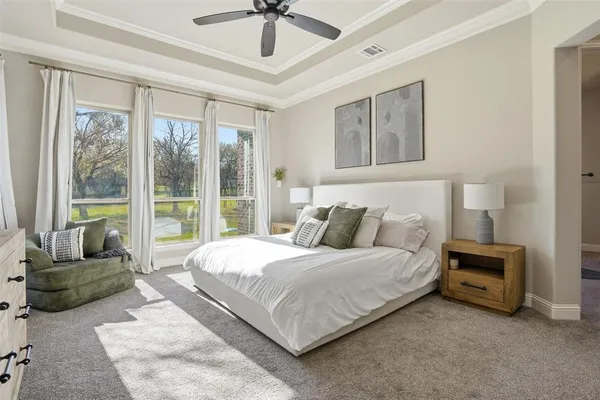 a bedroom with a large bed couch and a large window