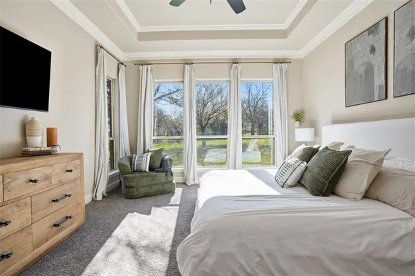a bedroom with a bed and a flat tv screen on the dresser