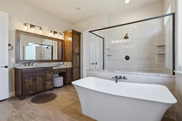 a bathroom with a tub a sink and mirror