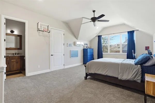 a spacious bedroom with a bed and a ceiling fan