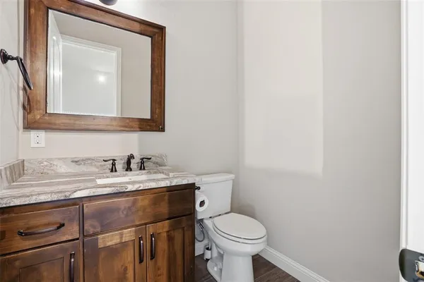 a bathroom with a toilet sink vanity and mirror