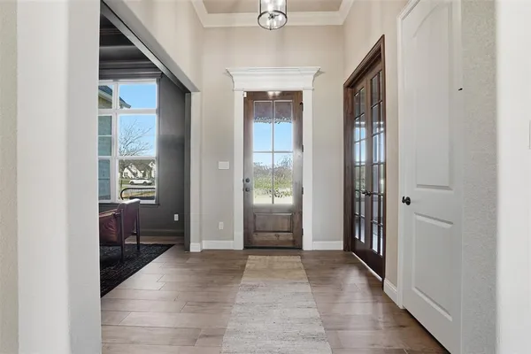 a view of a hallway with bathroom and wooden floor