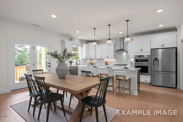 a view of a dining room and kitchen with a table chairs and refrigerator