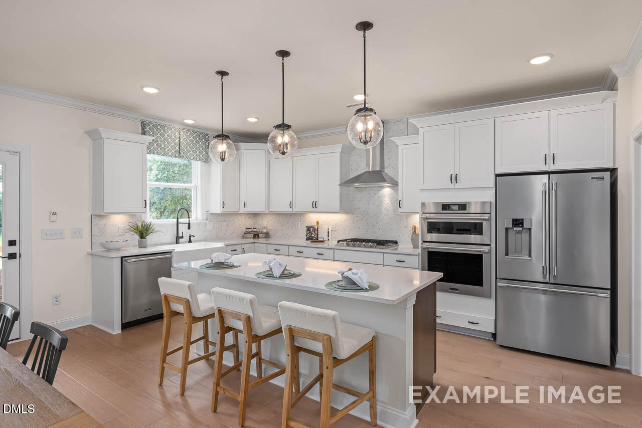 83 Crop Road Angier, NC 27501 - Photo 14 of 40 a kitchen with kitchen island white cabinets and stainless steel appliances