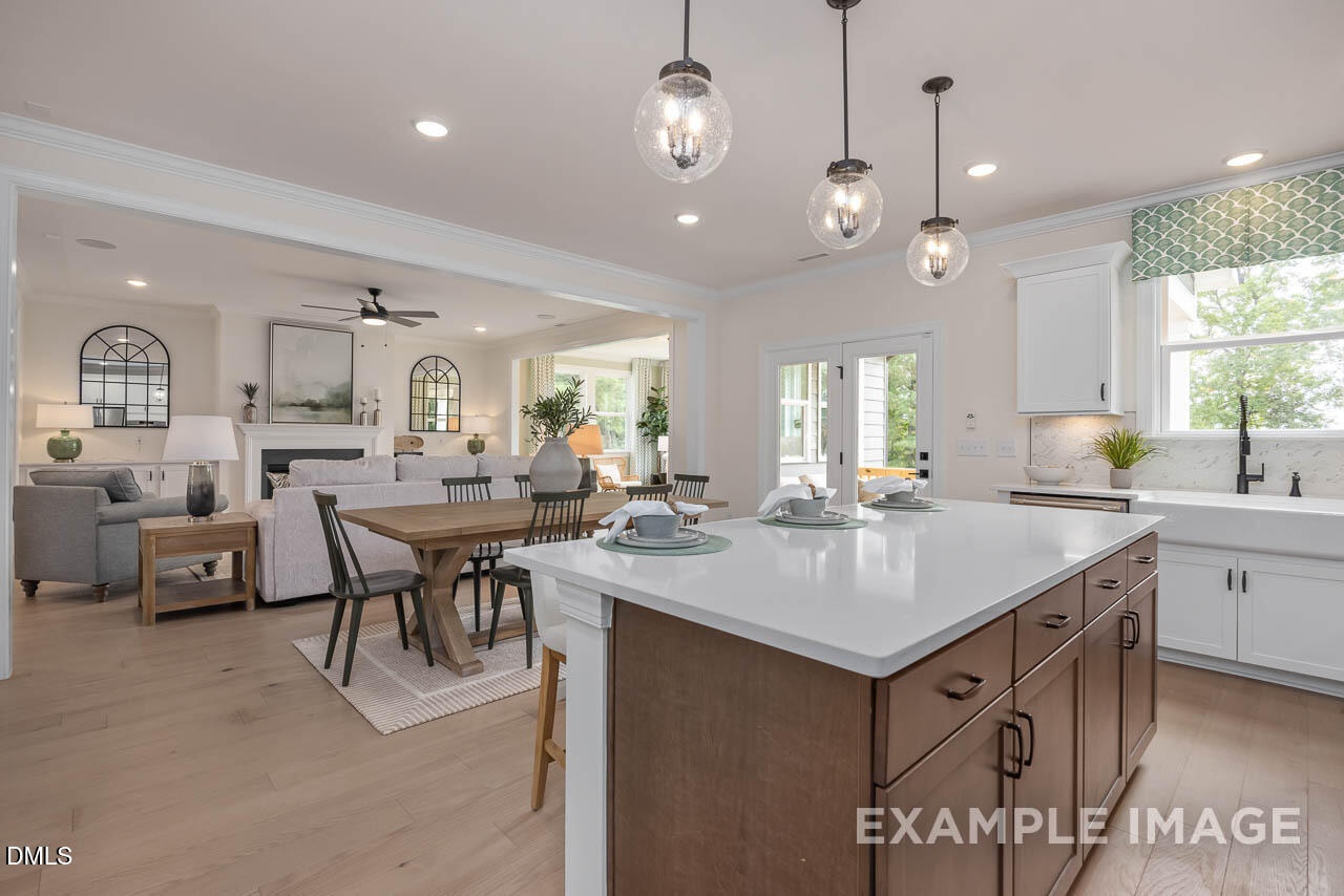 83 Crop Road Angier, NC 27501 - Photo 18 of 40 a kitchen with center island a sink dishwasher a dining table and chairs