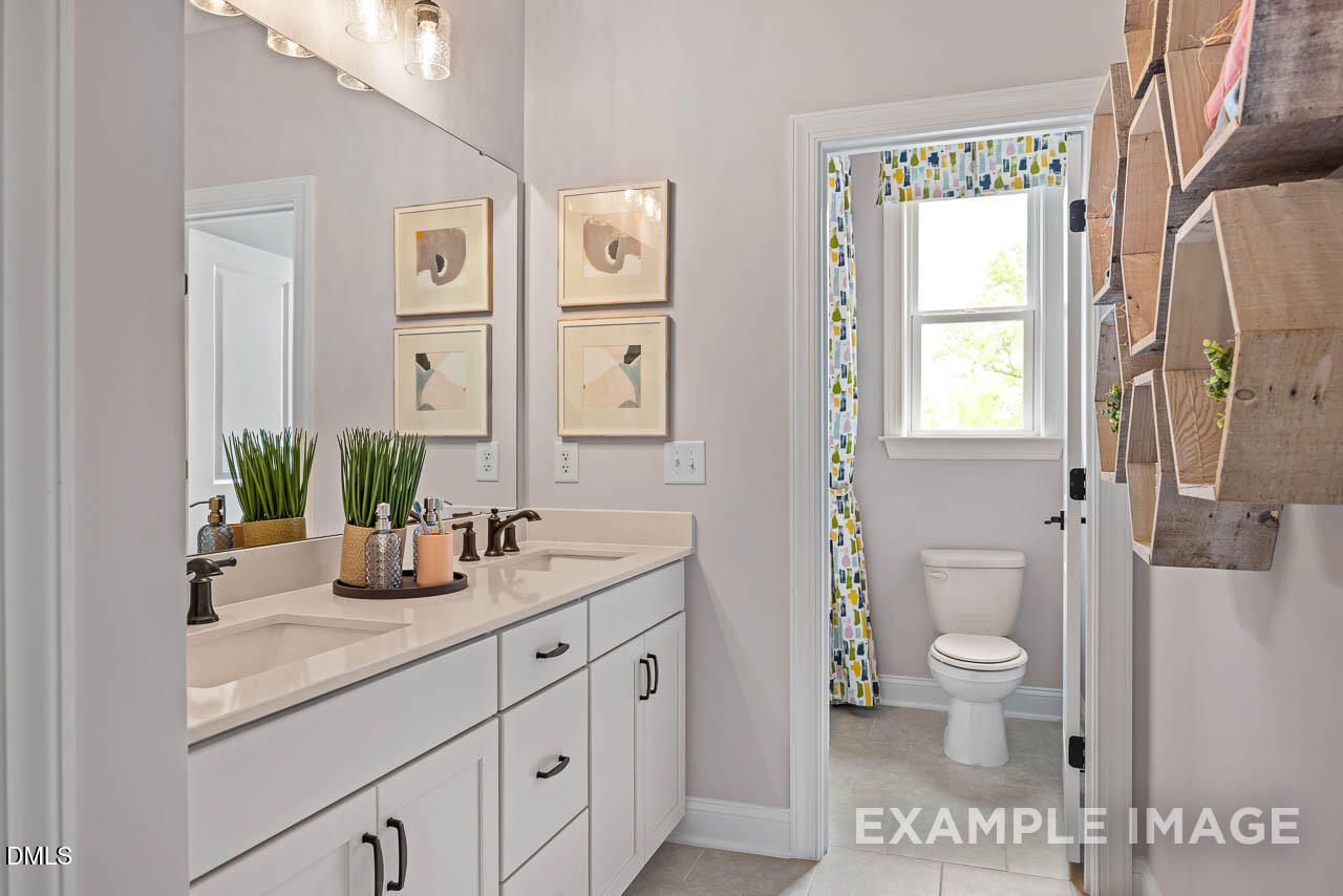 83 Crop Road Angier, NC 27501 - Photo 34 of 40 a bathroom with double vanity a toilet a and a window
