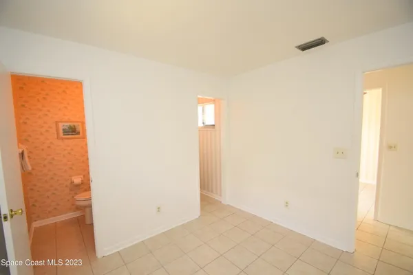 an empty room with a window and a ceiling fan