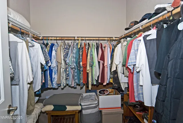 a view of walk in closet with clothes