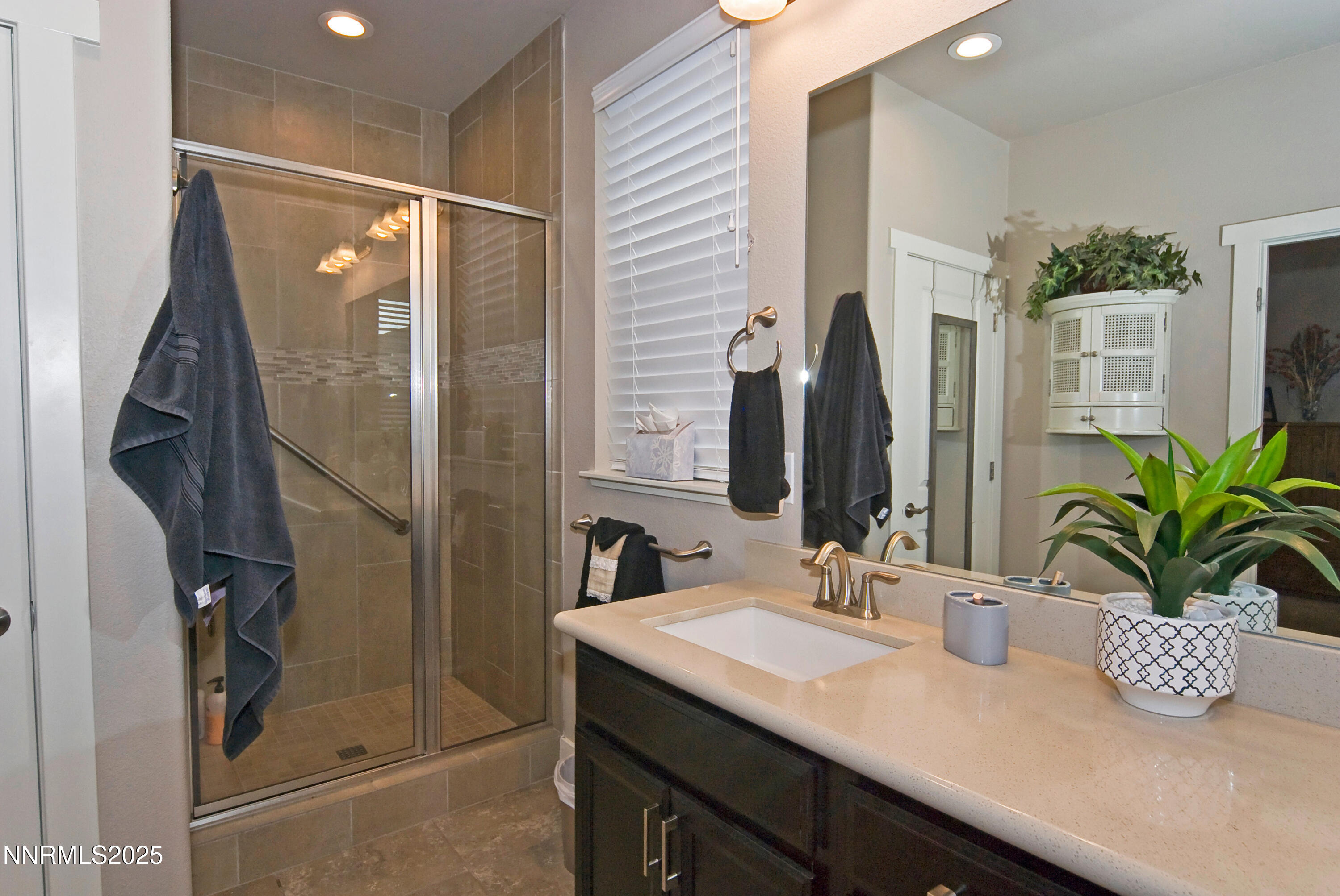 768 East Cottage Loop Gardnerville, NV 89460 - Photo 16 of 23 a bathroom with a granite countertop sink a mirror a vanity and a shower