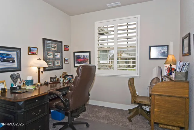 a view of a workspace with furniture and a window