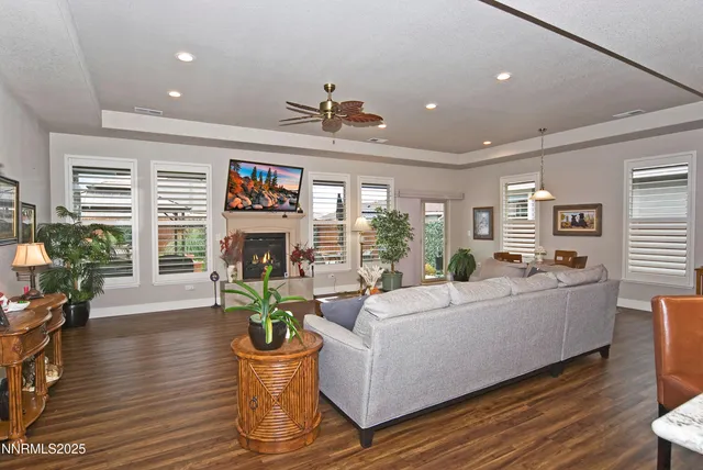 a living room with furniture a fireplace and a dining table with wooden floor