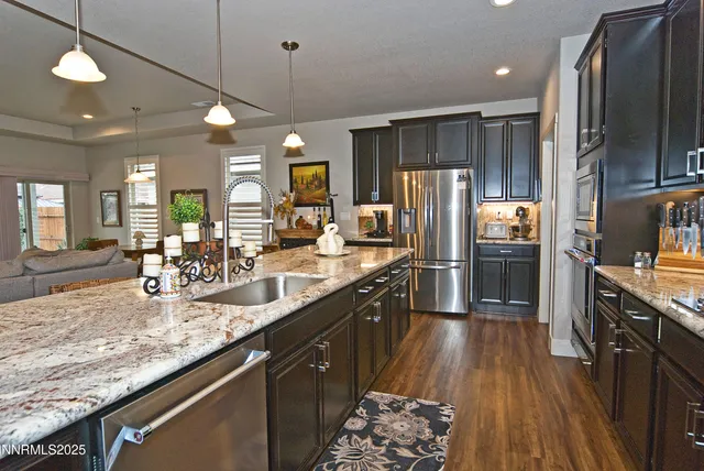 a large kitchen with granite countertop a large counter top appliances and cabinets