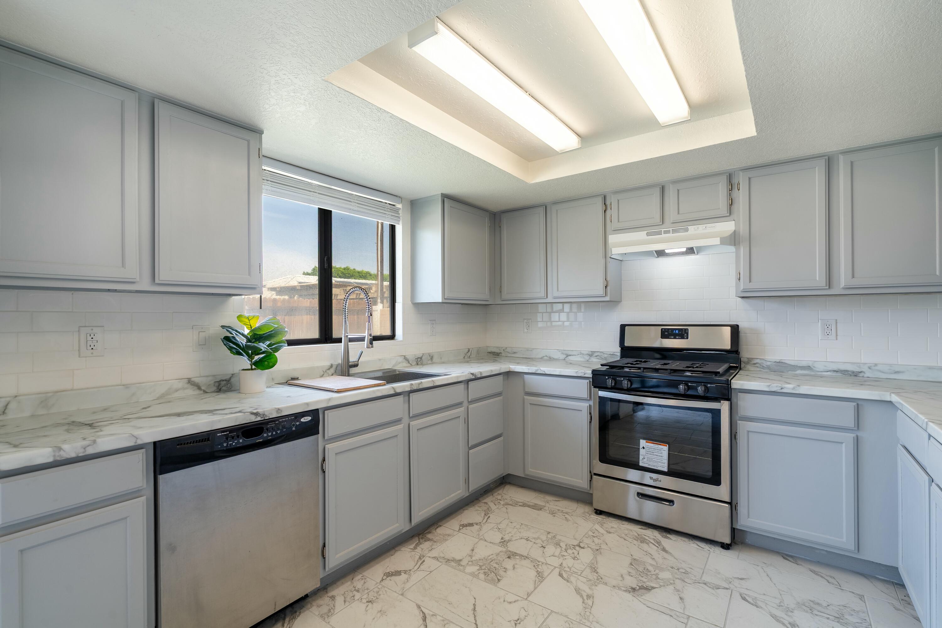 69290 El Dobe Road Cathedral City, CA 92234 - Photo 13 of 42 a kitchen with stainless steel appliances granite countertop a sink stove and cabinets