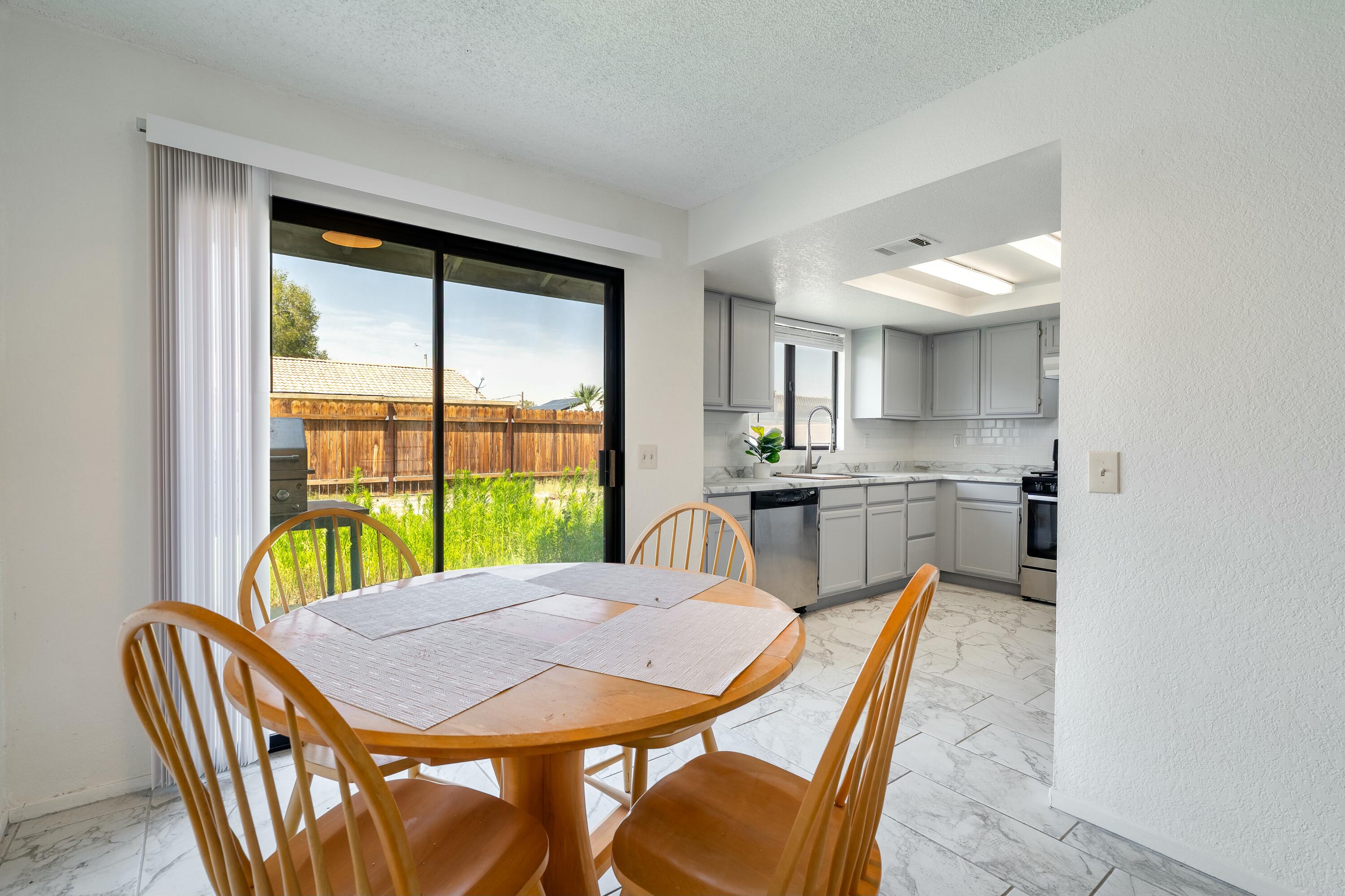 69290 El Dobe Road Cathedral City, CA 92234 - Photo 10 of 42 a view of a dining room with furniture a chandelier and wooden floor