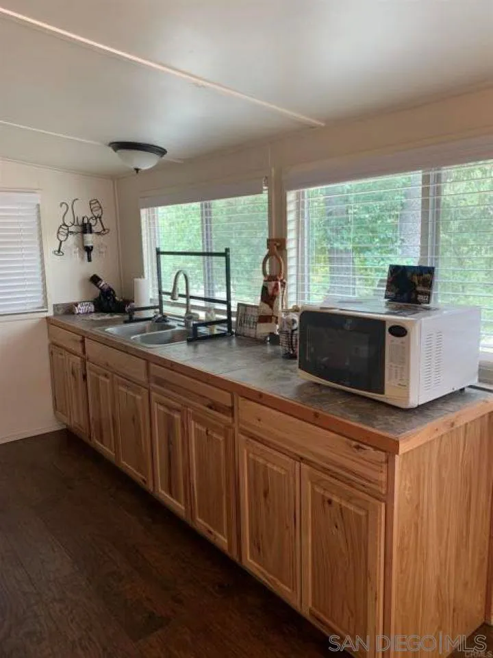 745 Boiling Springs Road Mount Laguna, CA 91948 - Photo 11 of 24 a kitchen with granite countertop a sink and white cabinets