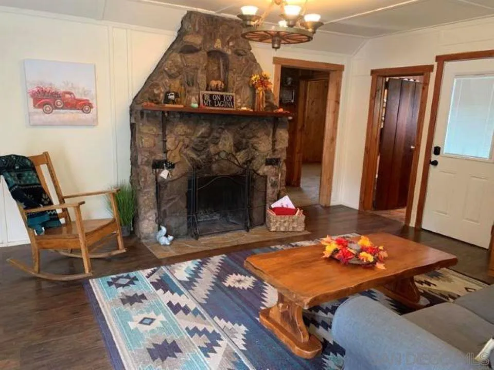 745 Boiling Springs Road Mount Laguna, CA 91948 - Photo 20 of 24 a living room with a fireplace and a table
