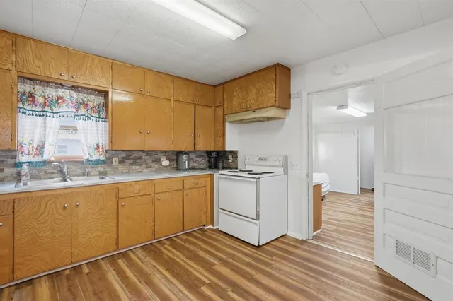 a kitchen with granite countertop white cabinets and white appliances