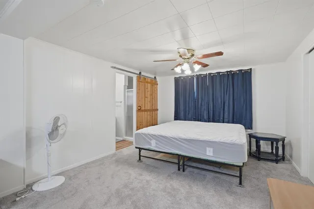 a bed sitting in a spacious bedroom and chandelier