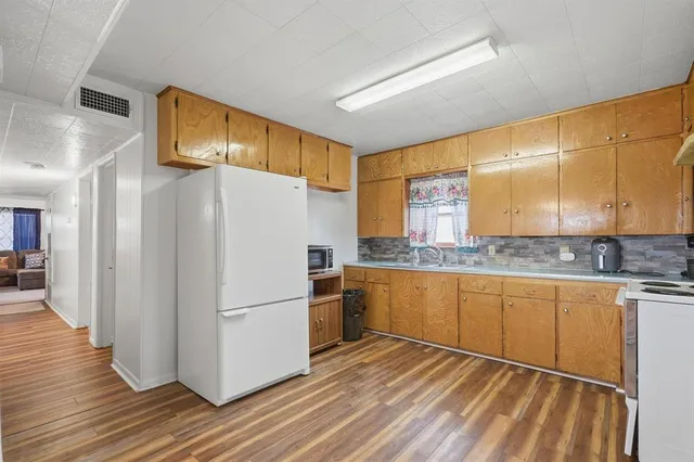 a kitchen with granite countertop stainless steel appliances a refrigerator and a sink