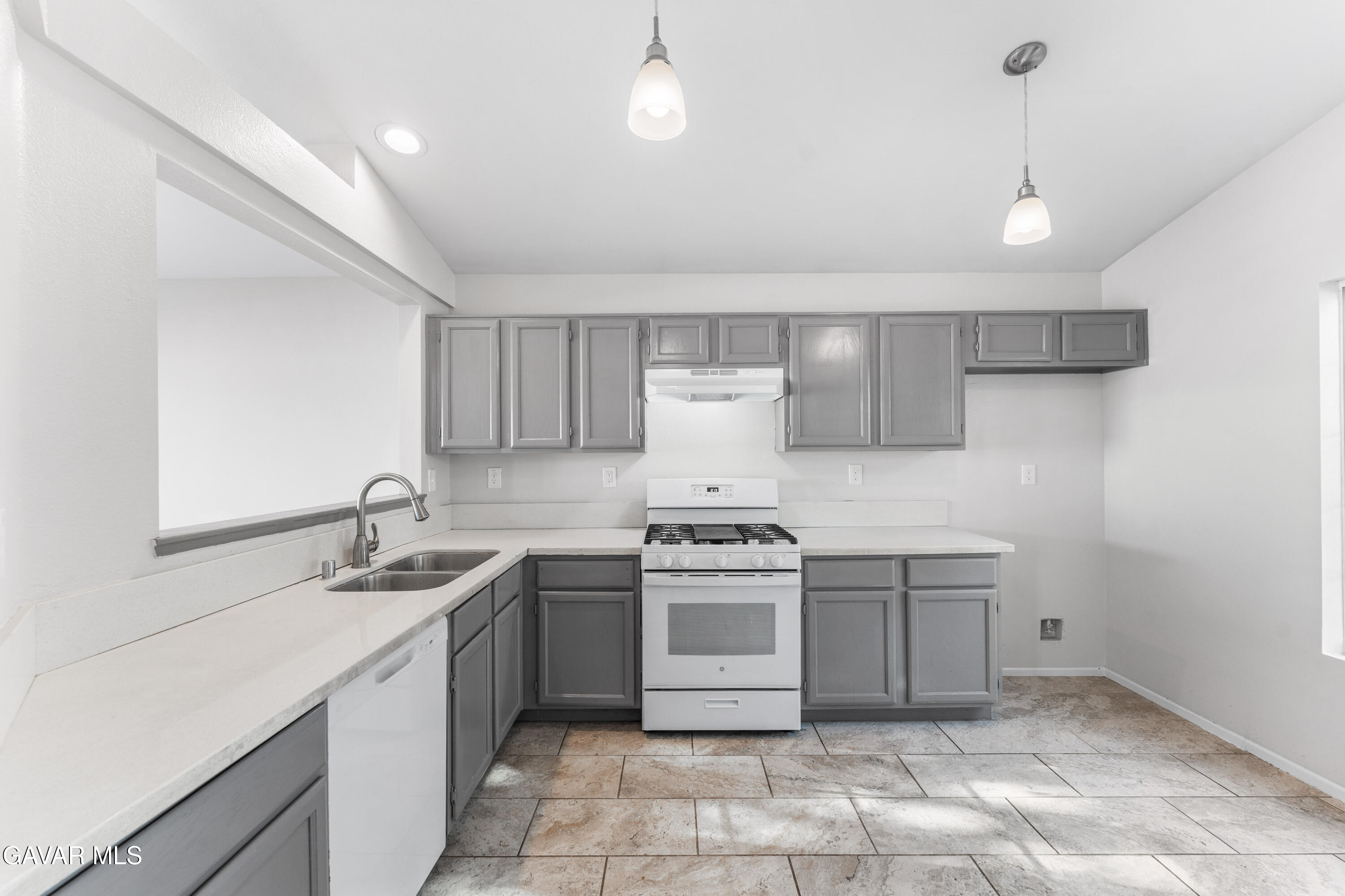 37031 Firethorn Street Palmdale, CA 93550 - Photo 15 of 36 a kitchen with a stove sink and cabinets